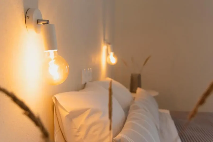 Cozy bedroom detail at Kamini Apartments Corfu with soft glow lighting and clean bedding for a relaxing holiday stay.